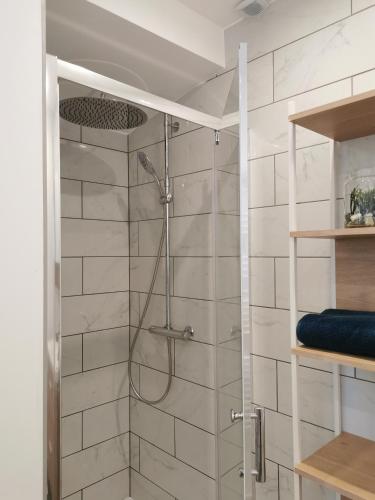 une douche dans une salle de bain avec du carrelage blanc dans l'établissement Loft 90m2 - Tout confort, à Libourne