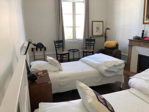 een kamer met 3 bedden en een open haard bij Beautifully renovated rooms on Place New York in Angoulême