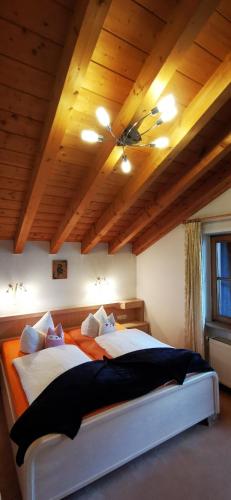 a bedroom with a large bed with a wooden ceiling at Landhaus Thaler in Mittelberg