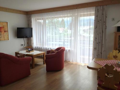 a living room with chairs and a large window at Alpenflair Ferienwohnung 228 Söllereck in Oberstdorf