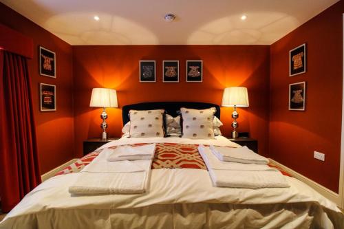 a bedroom with a large bed with orange walls at Three Horseshoes Leamside in Houghton le Spring