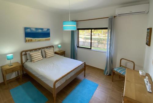 a bedroom with a bed and a window and a table at Vivenda Júlia e Tavares in Vilamoura