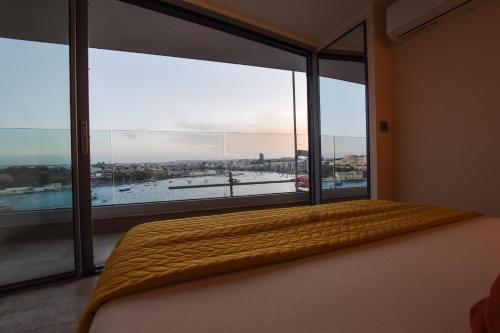Una cama o camas en una habitación de Unique Seafront Triplex Penthouse with Panoramic Bedroom & Rooftop Jacuzzi overlooking Valletta