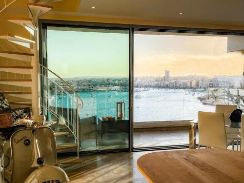 a dining room with a view of the water at Seafront Duplex Penthouse in Sliema