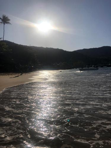 una spiaggia con il sole che splende sull'acqua di Canoa Abraão a Abraão