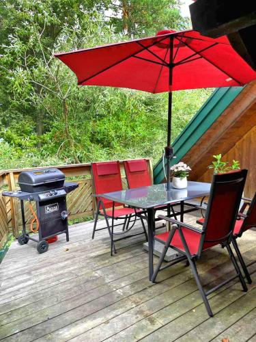 a table and chairs with an umbrella on a deck at Ferienwohnung Kleinkögeln in Kleinkögeln