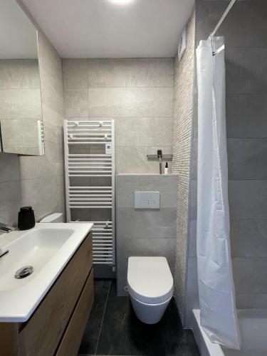 a bathroom with a white toilet and a sink at Moderne studio aan het strand in Oostduinkerke-bad in Koksijde