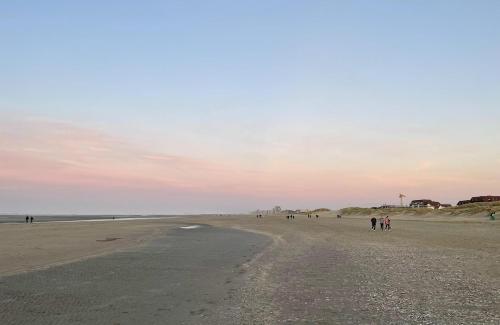 a group of people walking on the beach at Moderne studio aan het strand in Oostduinkerke-bad in Koksijde