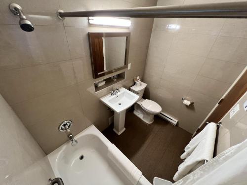 ein Badezimmer mit einer Badewanne, einem Waschbecken und einem WC in der Unterkunft Motel Du Chevalier in Gatineau