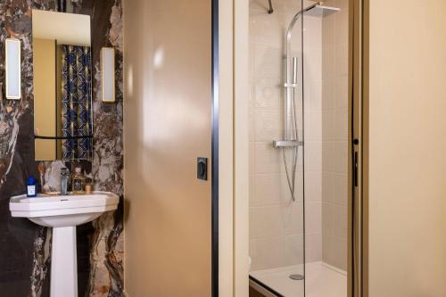 a bathroom with a sink and a shower at Hotel Le Rocroy in Paris