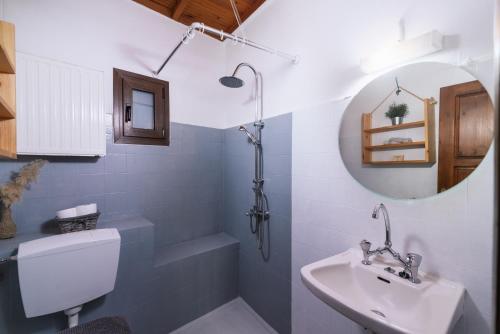 y baño con lavabo, aseo y espejo. en OVGORA - Aretousa sea view room, Kamilari village, en Kamilari