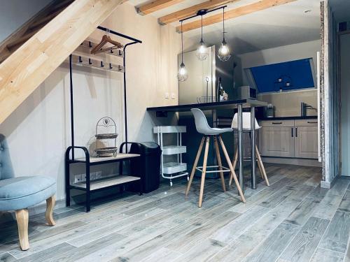 une cuisine avec un comptoir, une table et des chaises dans l'établissement Le Nid d'Amour 2pers / wifi / sauna, à Houssen