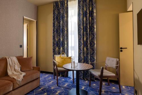 a living room with a couch and a table at Hotel Le Rocroy in Paris