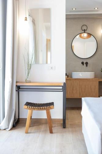 a bathroom with a sink and a bench and a mirror at Ionion Theasis villa Kallisti in Tsoukalades