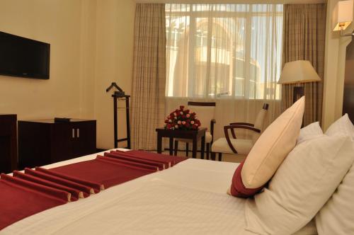 a bedroom with a bed and a living room at Harmony Hotel in Addis Ababa