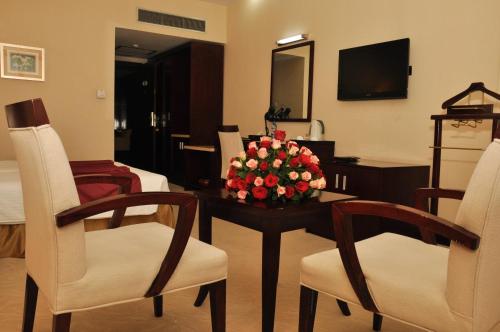 a room with a table with a vase of flowers on it at Harmony Hotel in Addis Ababa