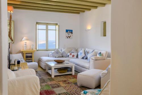 a living room with a couch and a table at Villa Isabella Family villa close to the beach in Mýkonos City