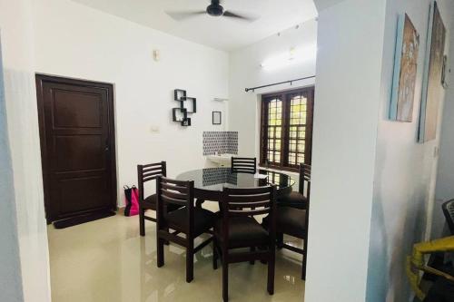 uma sala de jantar com mesa e cadeiras em KARIYIL KAYALORAM HOMESTAY em Shertallai