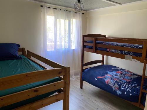 a bedroom with two bunk beds and a window at La Cayenne in Salazie