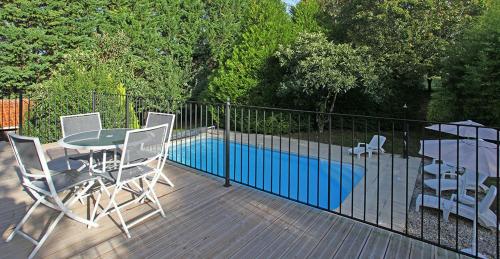 a patio with a table and chairs next to a pool at Superb contemporary 3 bed villa in Cancon