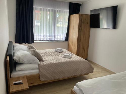 a small bedroom with a bed and a window at Apartament Miś in Zakopane