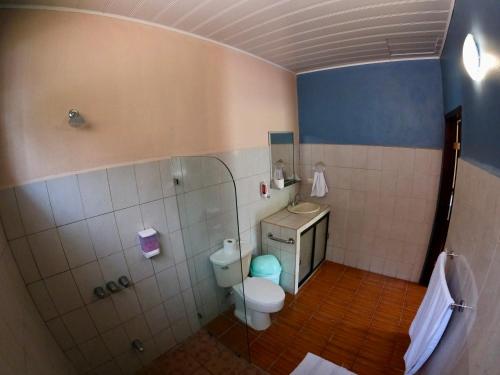 a small bathroom with a toilet and a shower at Lumbres Arenal in Fortuna