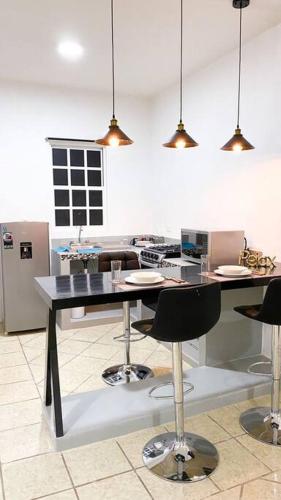 a kitchen with a table with chairs and a stove at Departamento Paraiso Cozumel in Cozumel