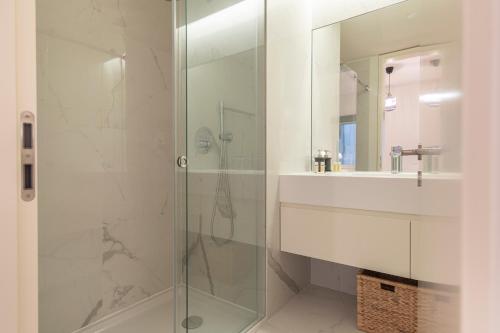 La salle de bains est pourvue d'une douche en verre et d'un lavabo. dans l'établissement Saldanha Flats I by Innkeeper, à Lisbonne