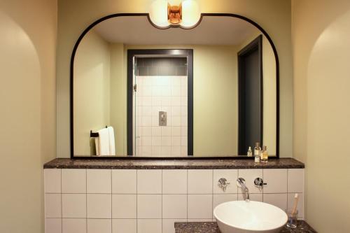 a bathroom with a sink and a mirror at The Hoxton, Shepherds Bush in London