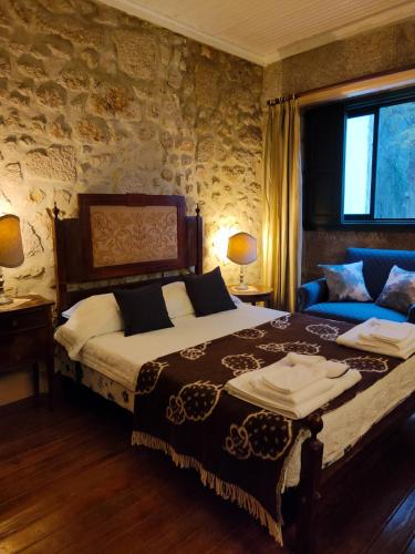 a bedroom with a large bed and a couch at Lugar da Pedra Alta - B&B - Private Historical Villa in Melo