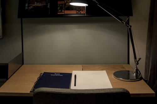 a desk with a lamp and a paper on it at GLAD Yeouido in Seoul