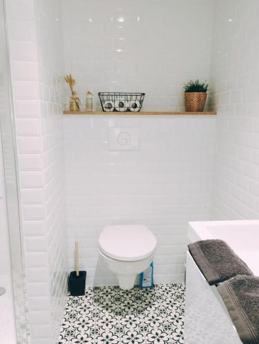 a bathroom with a white toilet and a black and white tile floor at La suite d'Arches in Charleville-Mézières