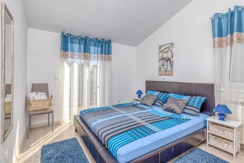 1 dormitorio con 1 cama grande con detalles en azul en Apartments Kardumovic, en Poreč