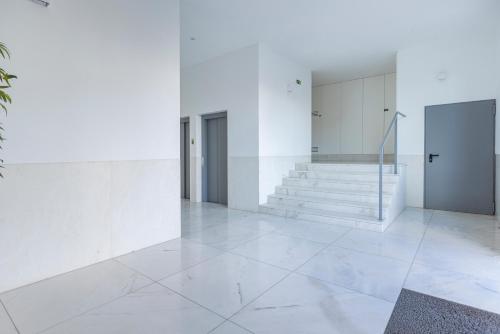 um átrio com paredes brancas e pisos e escadas brancos em Fabulous Terrace over Monsanto by Innkeeper em Lisboa
