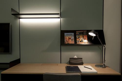 a room with a desk with a lamp and a book at GLAD Yeouido in Seoul