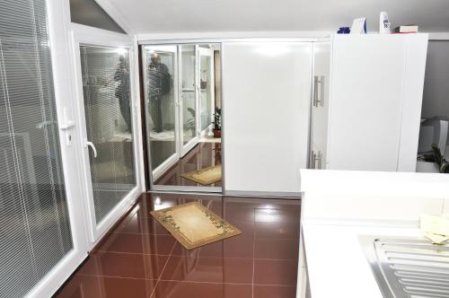 a bathroom with a glass shower with a box on the floor at Apartment Grcic in Sarajevo