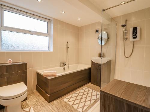 uma casa de banho com uma banheira, um WC e um chuveiro em Nantclwyd em Llangollen