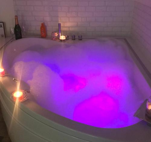 a bath tub with pink lights in it at Opsesija SPA in Kragujevac