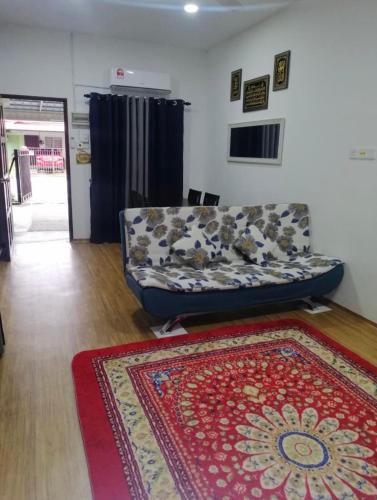 a living room with a couch and a rug at Sobey Laris Homestay RAZLEEN in Ketereh