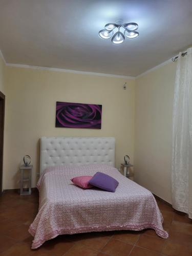 - une chambre avec un lit doté d'oreillers violets dans l'établissement La casa di Ilenia e Alessia, à Piana di Caiazzo