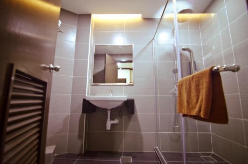 a bathroom with a sink and a shower with a mirror at Hotel Setia in Kluang