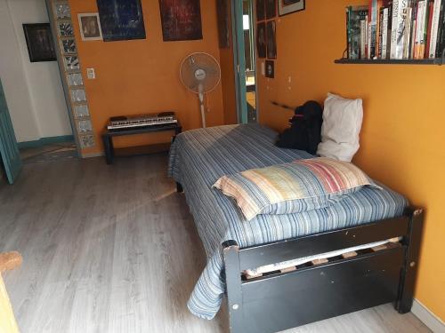 Cama pequeña en habitación con en Cuartos en el segundo piso de casa de artista en Flores en Buenos Aires