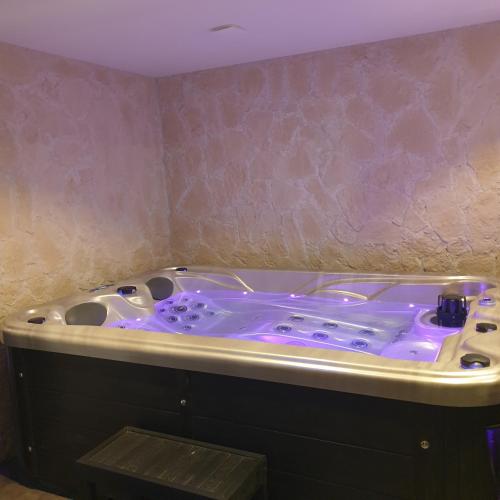 eine Whirlpool-Badewanne mit violetter Beleuchtung in einem Zimmer in der Unterkunft les chambres de Mélis in Crémieu