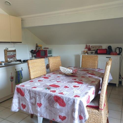 a kitchen with a table with a table cloth on it at les chambres de Mélis in Crémieu