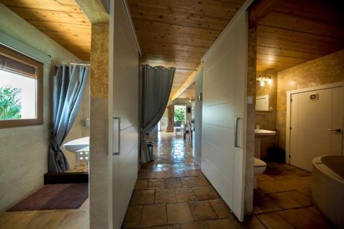 a hallway leading to a bathroom with wooden ceilings at The calm house in Santa Cristina d'Aro