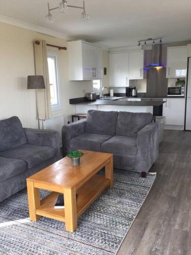 a living room with two couches and a coffee table at Marios Lodge in Padstow