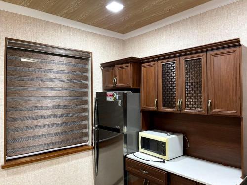uma cozinha com um frigorífico e um micro-ondas em Hotel Mohina em Samarkand