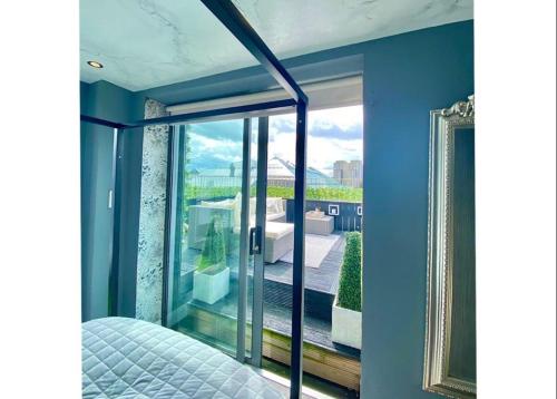 a bedroom with blue walls and a large glass window at Glasgow two bedroom Penthouse in Glasgow