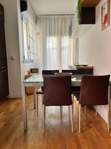 een eetkamer met een glazen tafel en stoelen bij Mi Casita in Bologna