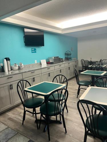 a room with tables and chairs and a kitchen at Howard Johnson by Wyndham Clarksville Tennessee in Clarksville